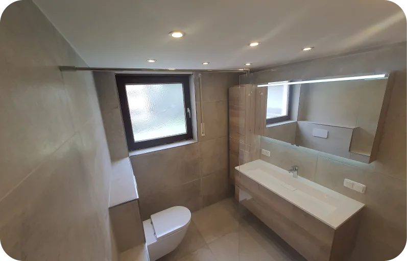 Badezimmer mit Waschtisch, Spiegel und hellen Wandfliesen